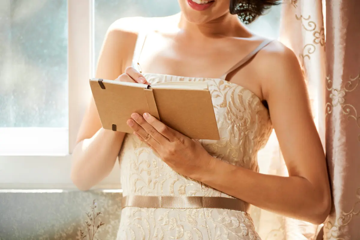 Questions To Ask A Wedding Venue Before You Book Bride taking notes for a wedding venue tour, tracking fees, restrictions, and coordination details